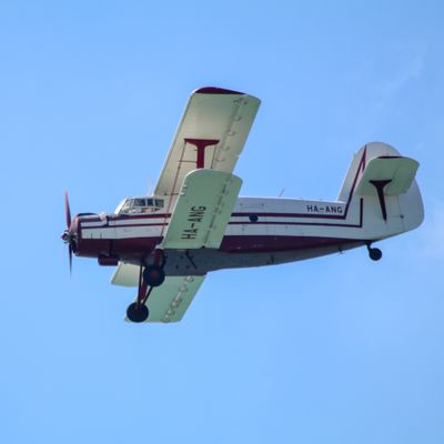 Antonov An-2 flying left against clear blue sky