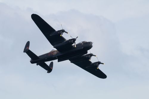 Lancaster bomber from underneath with bomb bay doors open against grey sky