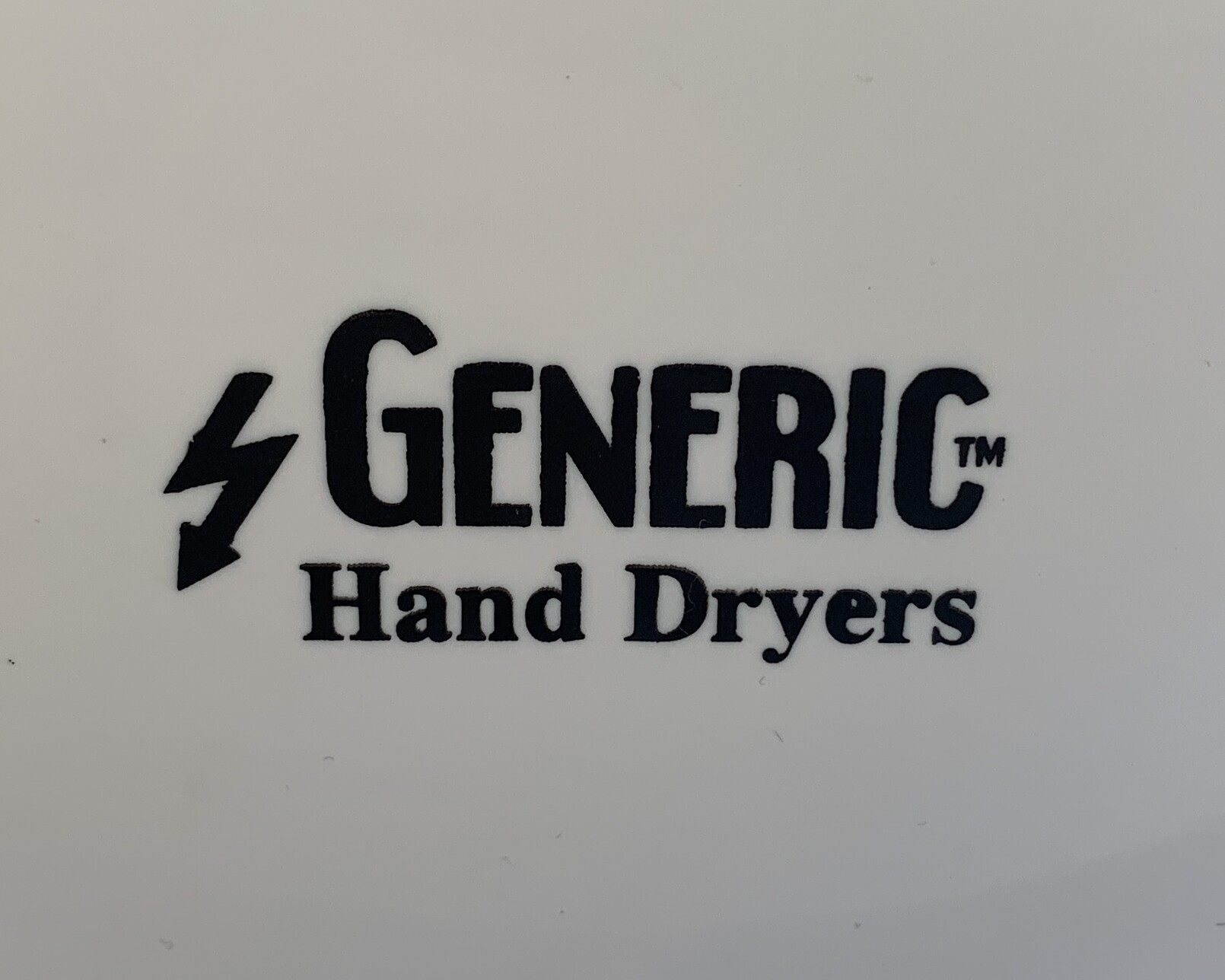 White plastic hand dryer casing with a black lightning bolt and black text reading â€œGenericâ„¢ï¸� Hand Dryersâ€�