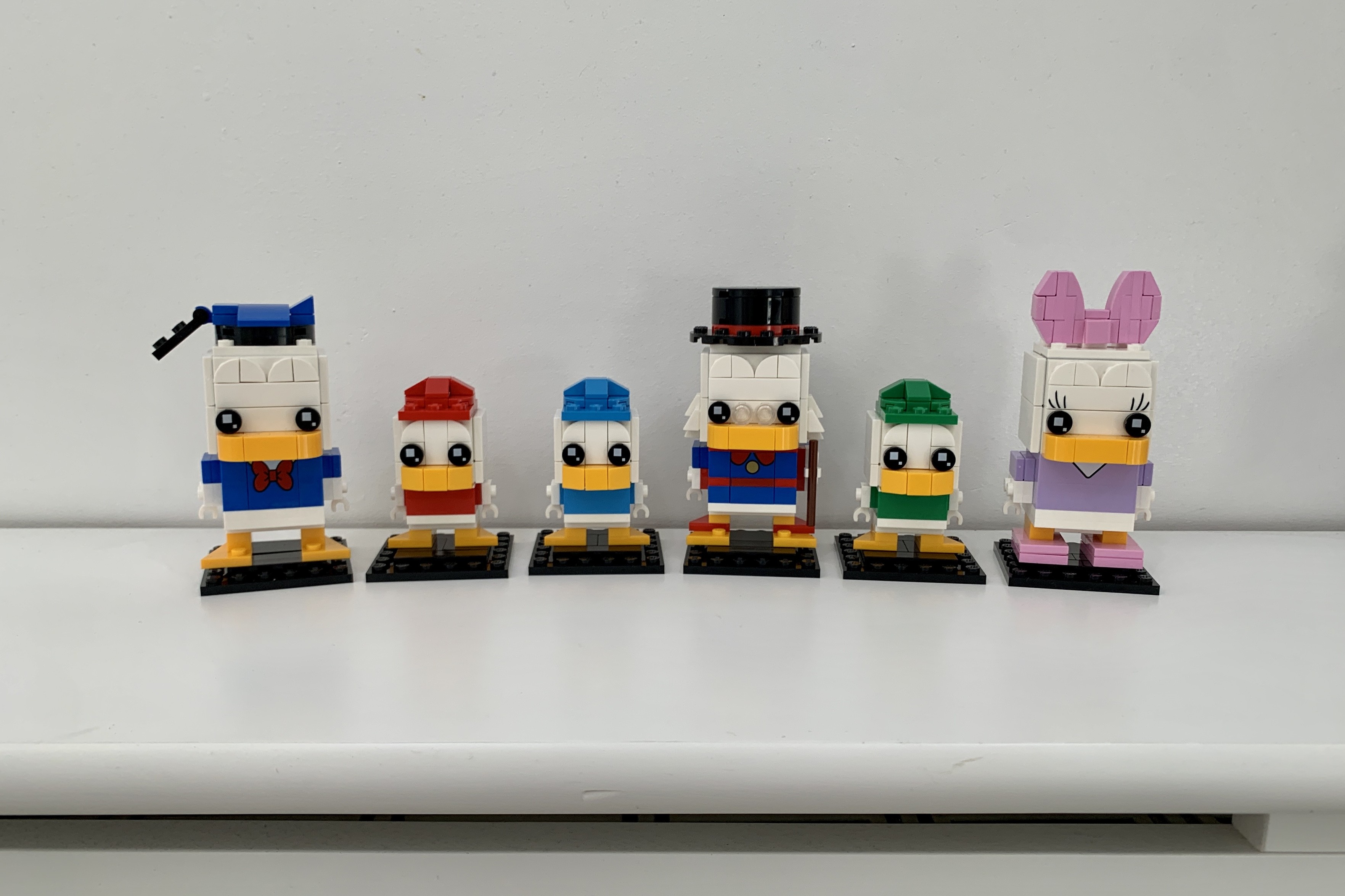 6 Lego BrickHeadz characters from the Disney Duck family. From left to right, Donald, Huey, Dewey, Louie, Scrooge, Louie and Daisy.