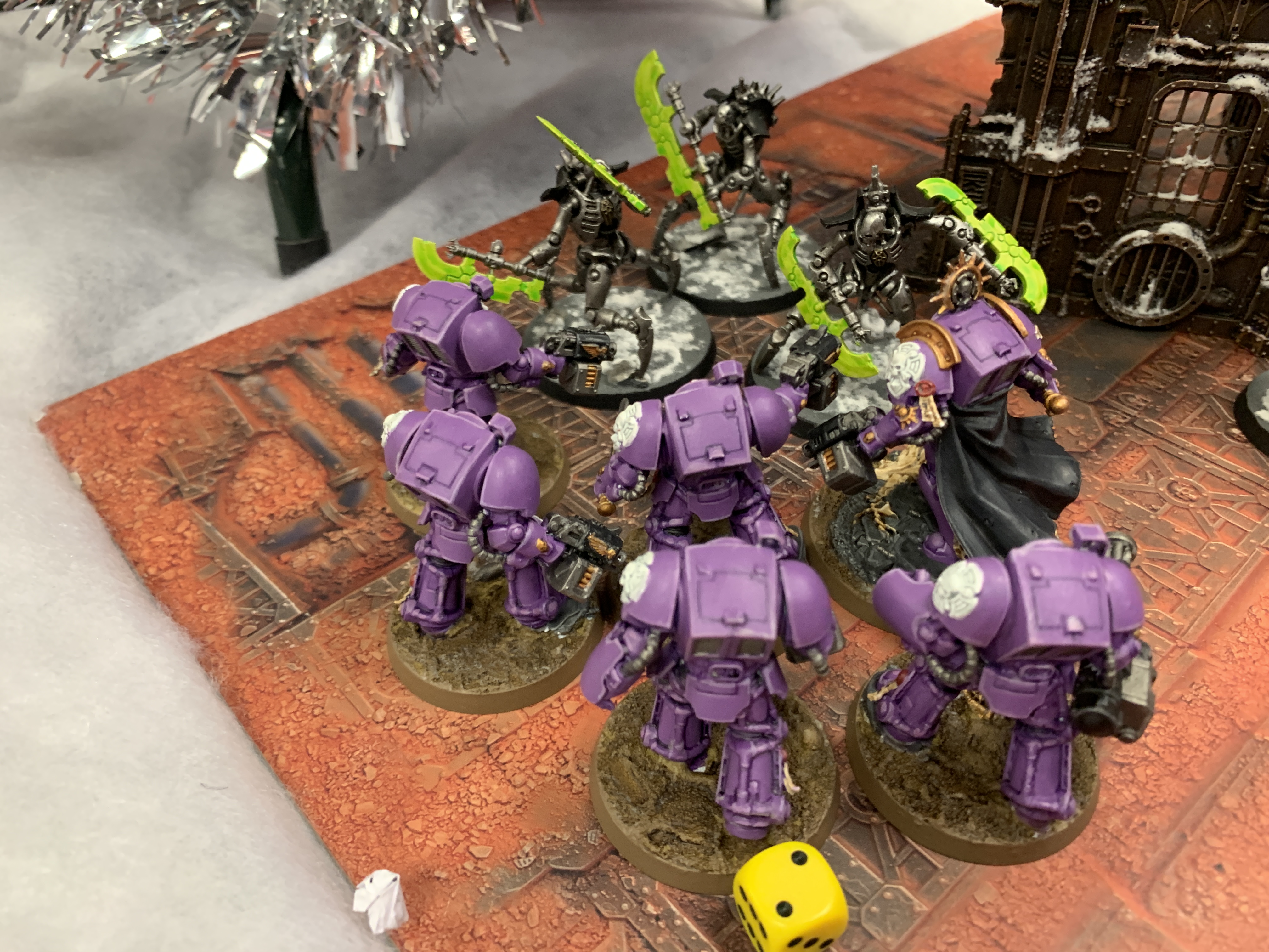 Six purple Space Marines in Terminator Armour facing three Necron Skorpekh Destroyers wielding light green blades