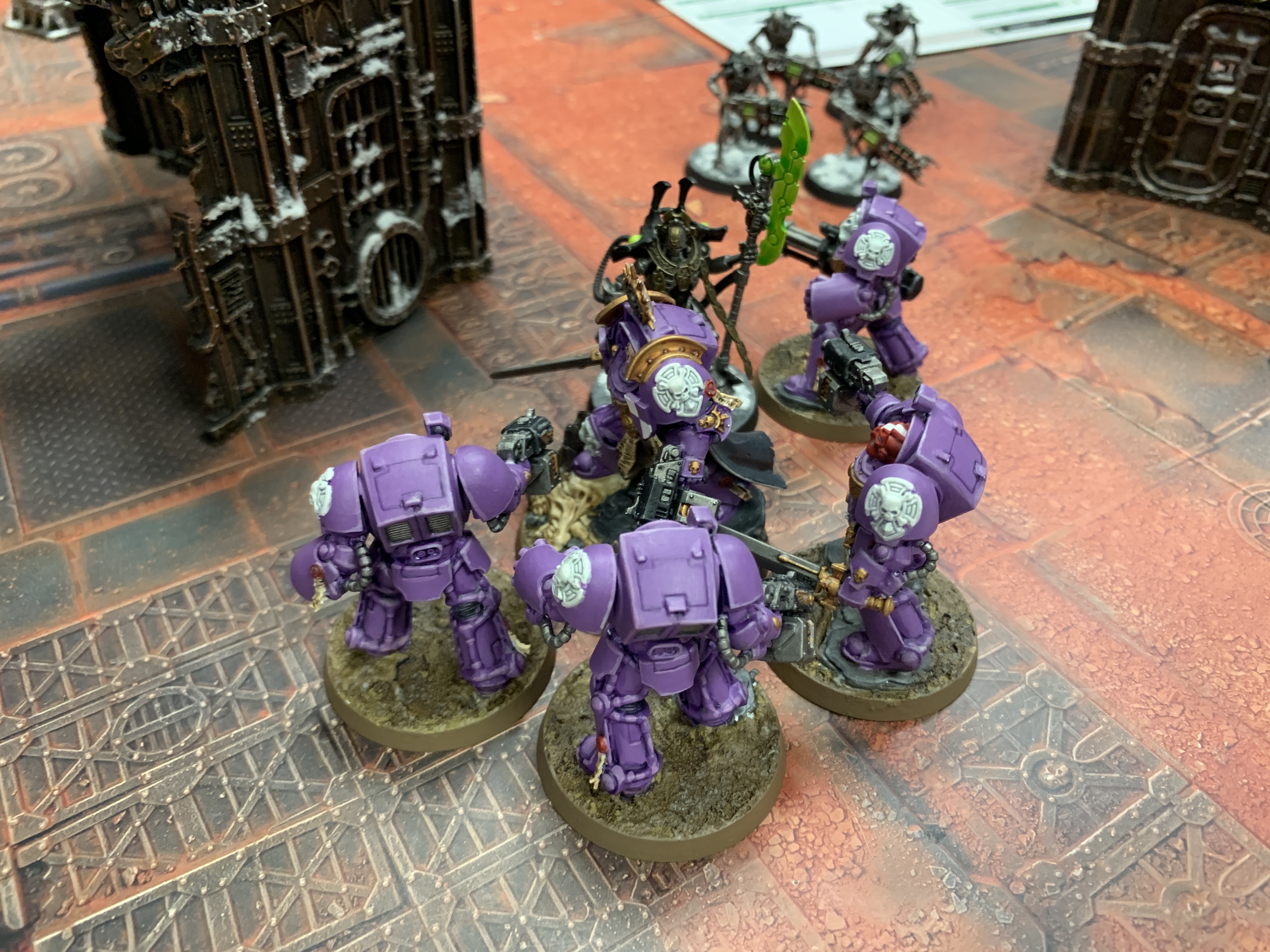 Five purple Space Marines in Terminator armour fighting a Necron Overlord with four Necron Warriors in the background