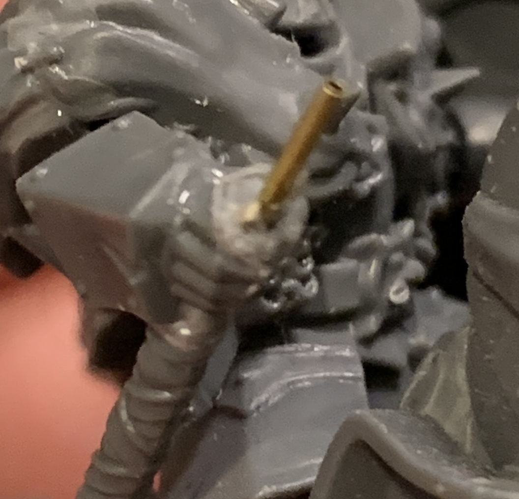 Zoomed in picture of me holding a Slaves to Darkness Chaos Knight. The picture is focused on the handle where the lance should be. In its place is a long brass rod with another brass rod in the same hole to provide support.