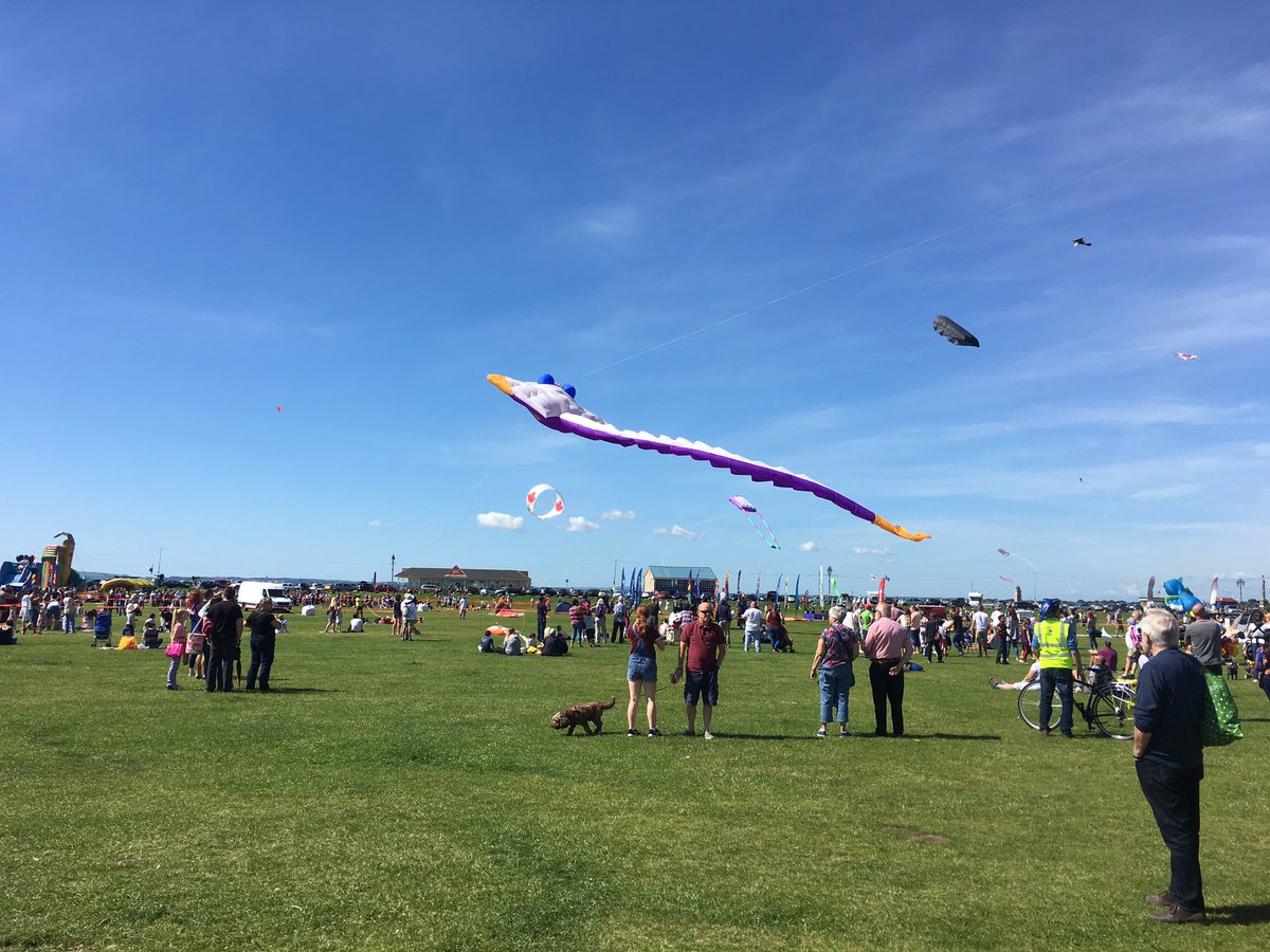Large kites flying above peoples heads